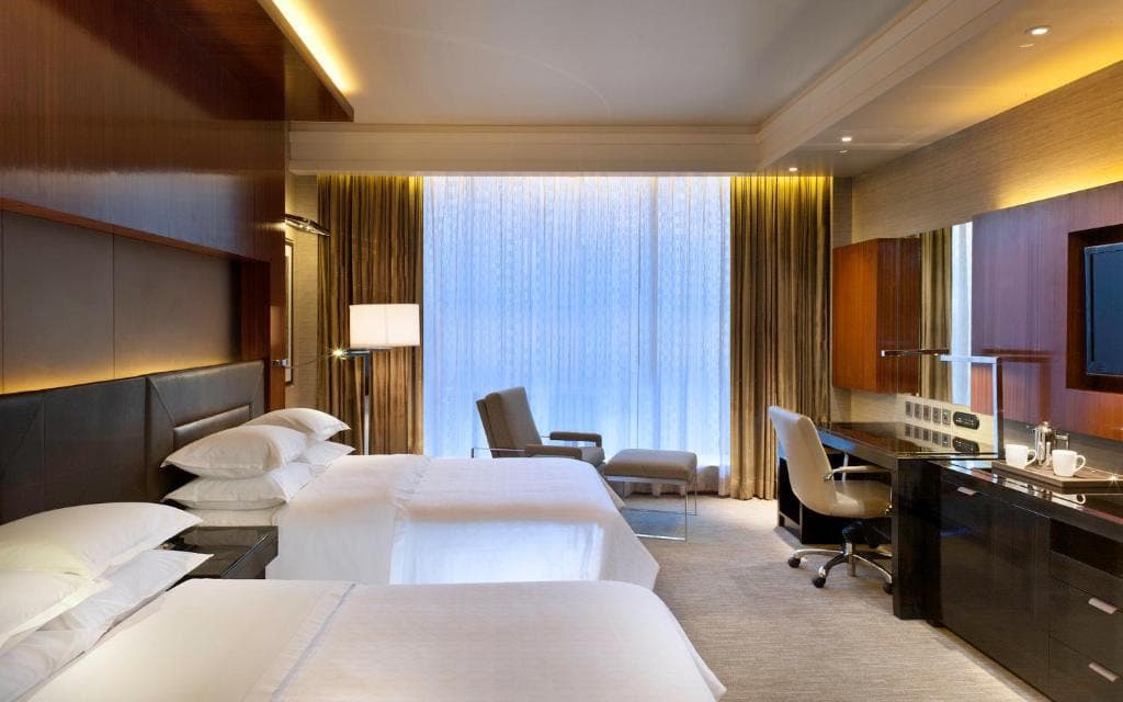 Hotel bedroom with two beds and warm lighting